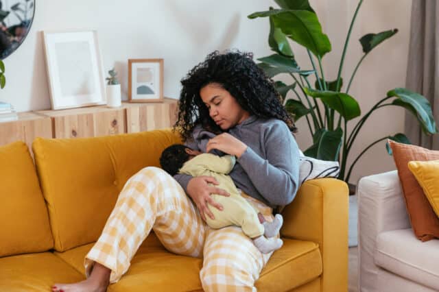 New mother feeding baby in pajamas